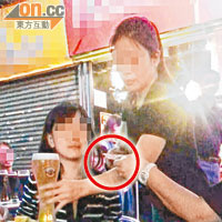 店員將啤酒捧至客人面前，並立即收取款項。（圓圈示）