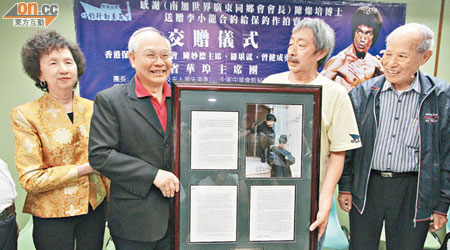 陳燦培（左二）把李小龍的電視劇合約連同劇照，捐予保釣行動委員會供拍賣籌款。（何天成攝）