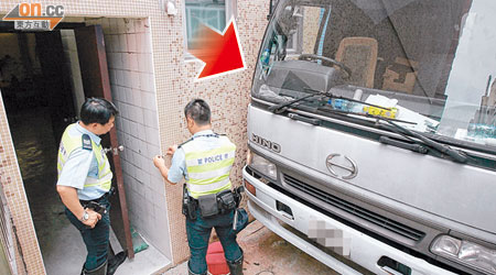 警員在懷疑貨車司機出事位置（箭嘴示），量度牆壁調查。（吳遠輝攝）