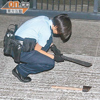 警員檢視地上遺下的開山刀及斧頭。