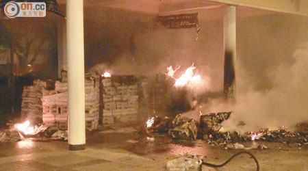 被焚的報紙冒出濃煙，現場的石柱亦被熏黑。（吳建明攝）