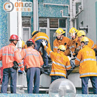 消防員將在慈正邨跳樓婦人的屍體抬落地面。（梁少恒攝）