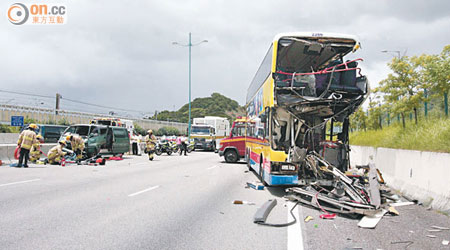 肇事巴士車頭撞至恍如廢鐵，客貨車則撞向石壆，消防在場拯救。（梁卓明攝）