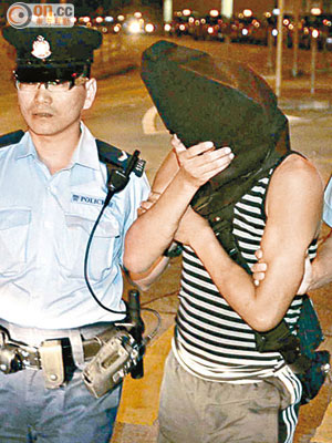 涉嫌在港鐵非禮男乘客的男子被警員帶署。（夏國威攝）