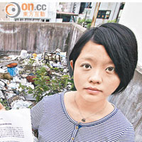 中西區區議員蕭嘉怡在堆滿垃圾的天台，展示要求食環署清理垃圾的信件。