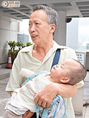 「非常父親」程朝武昨午抱着幼子俊盈到庭應訊。（蘇文傑攝）