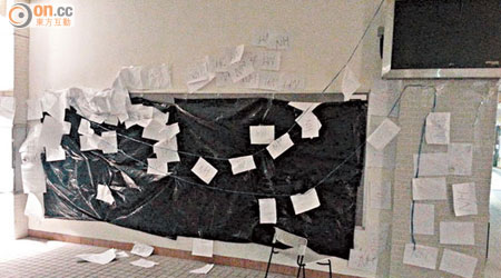 教院的民主牆被人用黑色膠袋覆蓋，膠袋上和民主牆範圍附近更被貼滿寫有「NH」字眼的紙張。