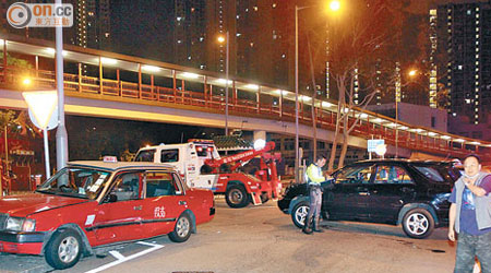 的士與四驅車相撞後，再撞倒路旁的路牌。右二為的士司機。（胡德威攝）