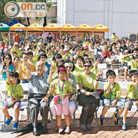 三百名小學生與家長身穿綠衣，參與快閃贈盆栽活動。