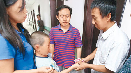 小斌斌父親郭志平（右二）接受捐助。（中新社圖片）