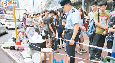 荃灣手機店外留下「果迷」排隊用的椅子，警員在場調查。（曾紹良攝）