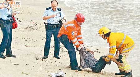 蹈海老婦的屍體被拖回岸上。（黃子源攝）