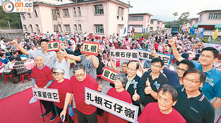 石仔嶺花園「老人村」昨舉行盆菜宴，長者高舉標語希望留在石仔嶺繼續生活。