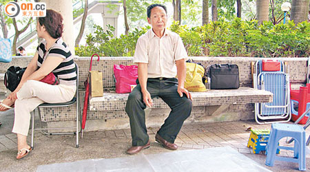 明先生（右）帶同大膠袋到幼稚園外的公園，打算長期留守，用大膠袋鋪在外面打地鋪睡覺。（何昀諺攝）