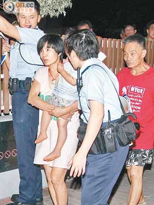 曾射水救火的胡先生（右一）和鄰居周太及其兒子（左二），在警員帶領下疏散。