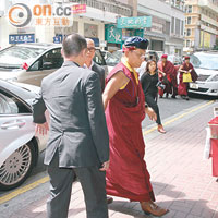 大劉嘅保安同司機為一眾喇嘛開車門，並護送喇嘛入飯堂。