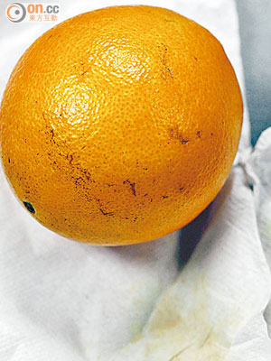 本報記者用熱水浸泡本地購買的江西臍橙，並用紙片擦拭表面後，發現輕微橙黃顏色脫落。