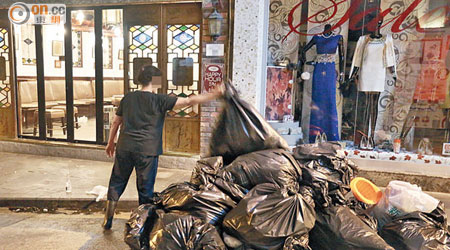 士丹頓街<br>食肆職員肆無忌憚將一大袋黑膠袋垃圾拋在街上。（朱先儒攝）