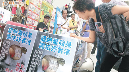 「正義聯盟」義工昨午在旺角行人專用區發起「罷絕毒蘋果，團結好香港」簽名行動。（蘇文傑攝）