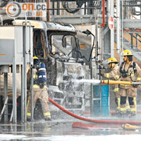 消防員向起火運油車射水灌救。