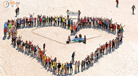 參加者抵達大浪西灣後排成心形，表達對沙灘的愛護及關注。（黃仲民攝）