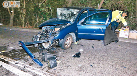 私家車車頭嚴重毀爛，警員在現場調查。（楊偉嶽攝）