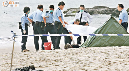 警員在沙灘檢查女屍。（曾志恆攝）