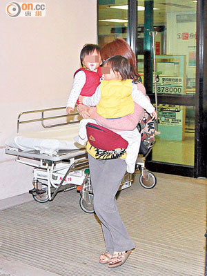 受傷母親抱着一對孖生女兒同往醫院。（賴南秋攝）