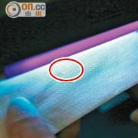 本港三款快餐店的餐紙巾在紫外燈照射下，浮現零星的螢光點（紅圈示）。