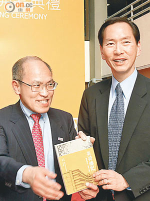 香港青年旅舍協會行政委員會主席黃奕鑑（左）送咗本《美荷樓記》畀陳智思（右）。