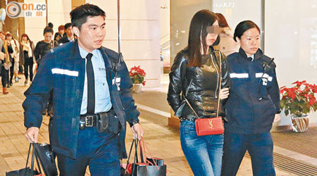 其中一名被捕內地女子打扮高貴，警員將她連同所攜的三袋物品帶署。