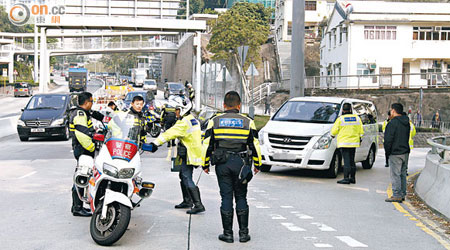 被撞警方電單車停在路邊，警員在場調查。（曾紹良攝）