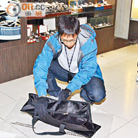 警員檢查疑賊人遺下的手提袋。