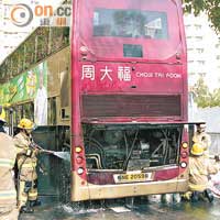 消防員將火救熄後仍向車廂引擎射水戒備。（黃智康攝）