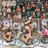 表演者一邊吹奏着銅管樂器，一邊踏單車，看得市民驚心動魄。
