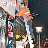 消防員在大埔爬上店舖閘頂救貓。