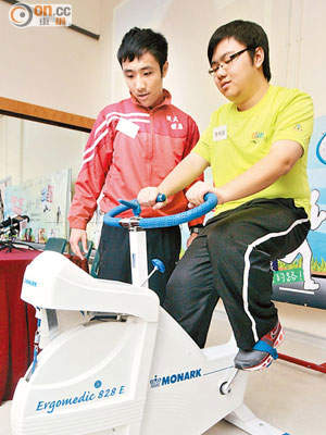 李梓峰（右）在組長李兆東（左）指導下，透過踩單車增強心肺功能。（袁志豪攝）