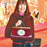 女童軍副會長陳曦齡拎起裝上電話盤嘅手袋，夠晒新潮。