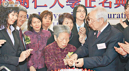 樹仁經多年努力後正名為大學，鍾期榮與胡鴻烈切蛋糕慶祝。（資料圖片）