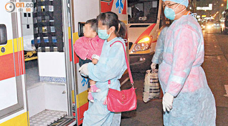 穿上保護裝備的救護員到女嬰土瓜灣寓所，接走女嬰及其家長。（林兆崙攝）