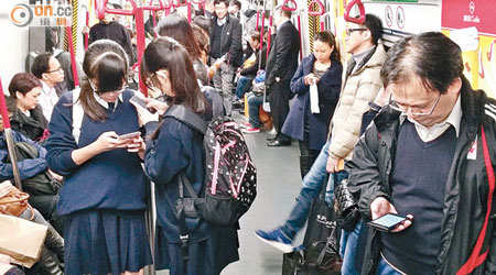 香港<BR>「低頭族」在港鐵列車上俯拾皆是。（李國健攝）