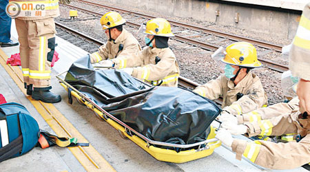 消防將跳軌女子屍體移上月台。（高潤榮攝）