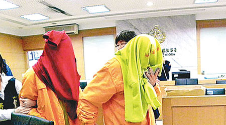 兩名港女租霸昨以毛巾蒙頭離開台北地檢署。　（互聯網圖片）