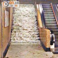 雨水由港鐵黃大仙站出口的樓梯湧入大堂。（讀者提供）