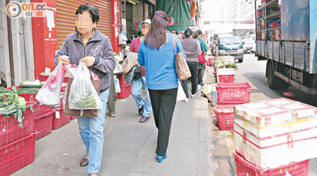 石硤尾巴域街一間菜檔阻街範圍之廣，行人路及馬路均已被攻佔。