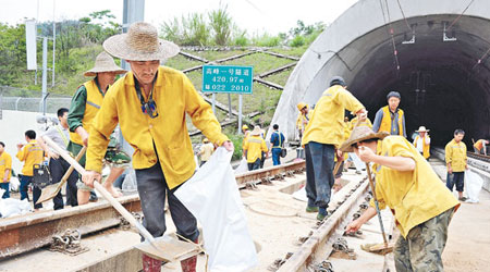 深高鐵路段清理<br>廣深港高鐵距深圳北站約四公里的路段遭山泥阻塞，職員須搶險清理。（中新社圖片）