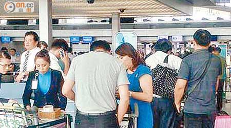 大批遊客在胡志明市機場長榮航空櫃台前辦理登機手續。