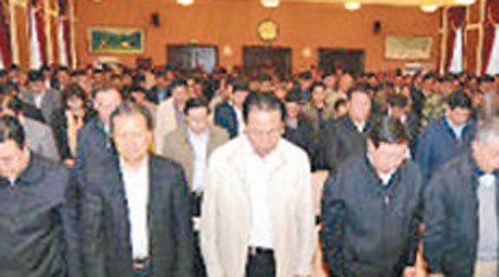 新疆維吾爾自治區幹部大會，幹部向恐襲遇難者默哀。（互聯網圖片）