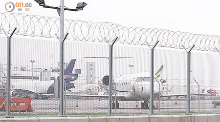 香港機場因泊位爆滿，有商用飛機停泊在貨機旁。