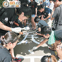 港大學生繼承傳統<br>港大學生為太古橋上的悼念六四字句添上新漆。（黃永俊攝）